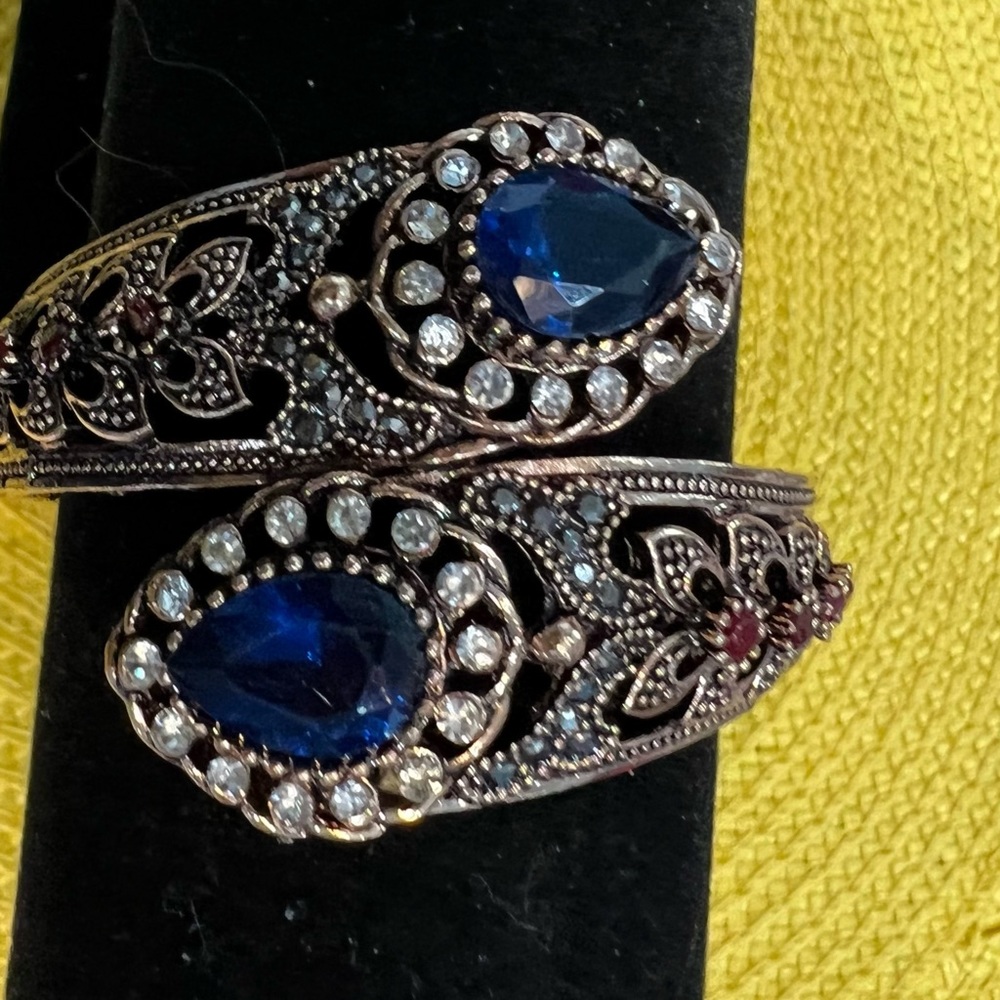 Intricate bypass bracelet with Sapphire colored And clear stones Excellent…